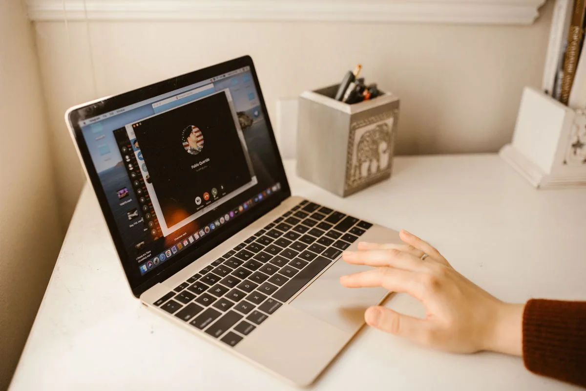 Video conversation on a laptop; illustrative remote-interpretation photograph