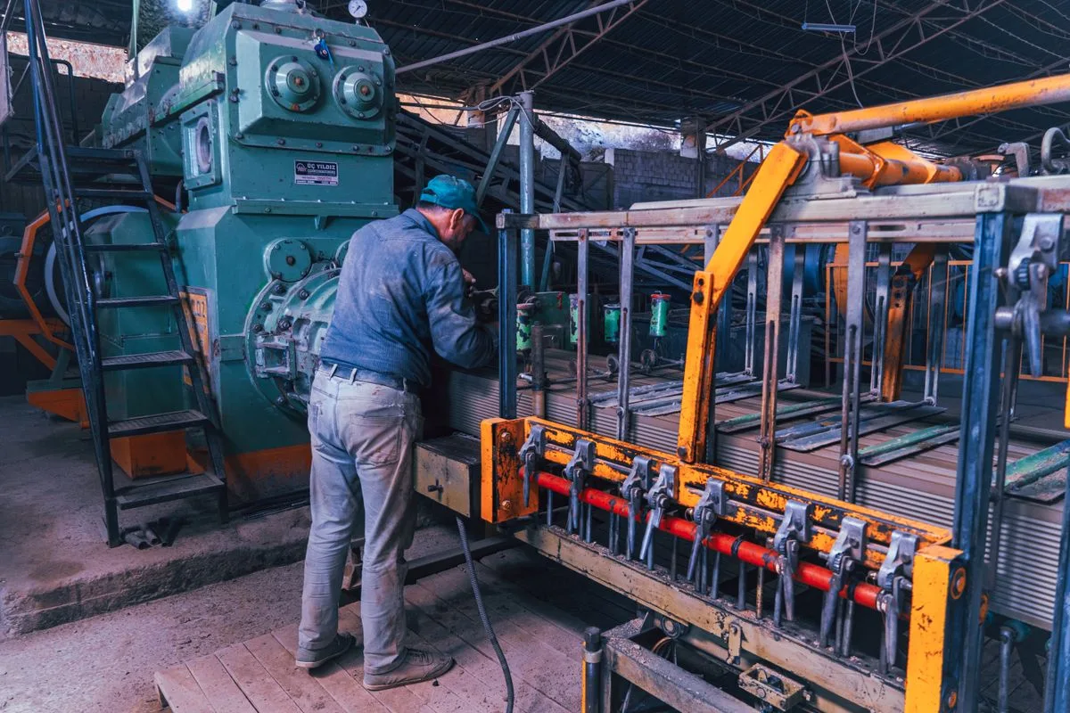 Worker operating manufacturing machinery; illustrative manufacturing-association photograph
